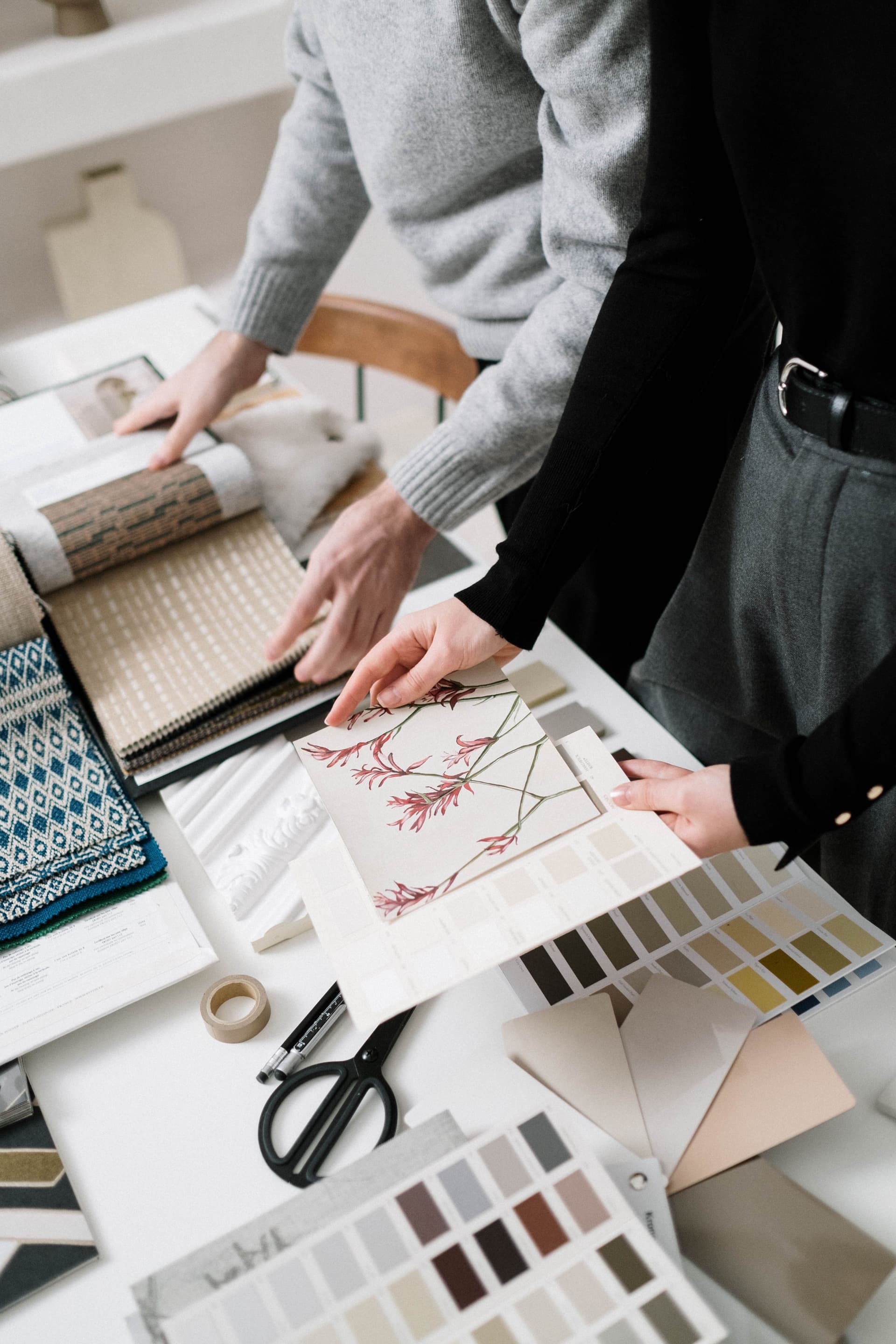 Interior design studio with specification book software open on a laptop alongside material samples