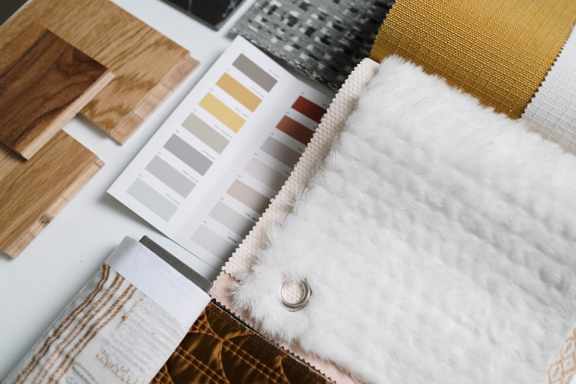 Material and finish samples spread out for a hotel property improvement plan review, representing hotel PIP software
